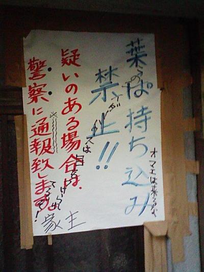 張り紙には「葉っぱ持ち込み禁止！疑いのある場合は警察に通報します」と書いてあり、その上に落書きで「オマエは来るな」とか「このライダーハウスは目をつけられてるぞ」とか書かれています